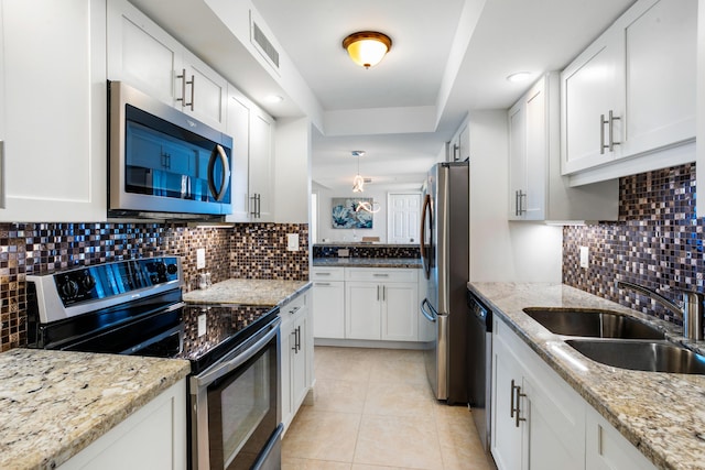 kitchen featuring light stone countertops, sink, white cabinets, and stainless steel appliances