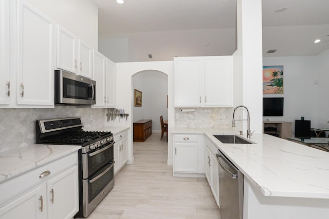 kitchen featuring light stone counters, sink, white cabinetry, and stainless steel appliances