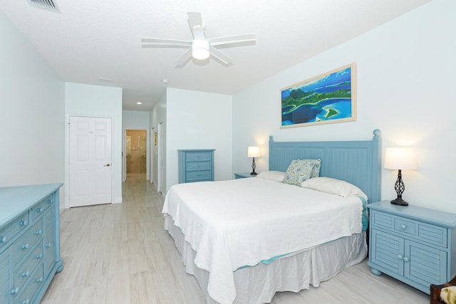 bedroom featuring a textured ceiling, light hardwood / wood-style flooring, and ceiling fan