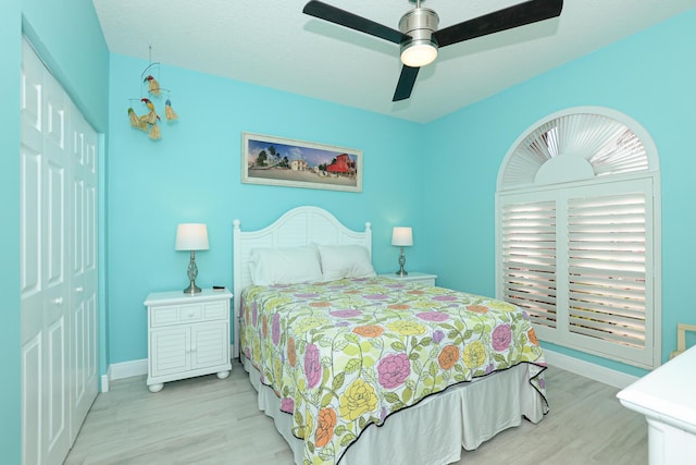 bedroom with ceiling fan, a closet, and light hardwood / wood-style floors