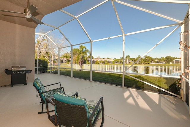 view of patio with a lanai, area for grilling, and a water view