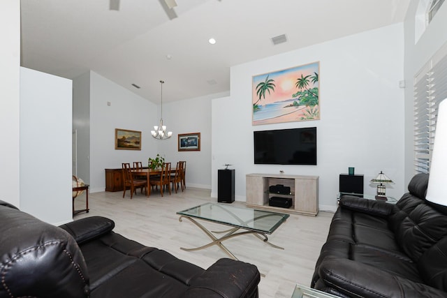 living room with a notable chandelier, high vaulted ceiling, and light hardwood / wood-style flooring