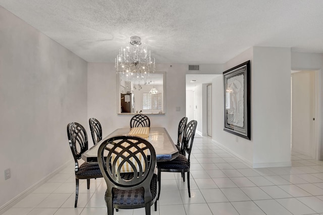 tiled dining space featuring a textured ceiling and a notable chandelier