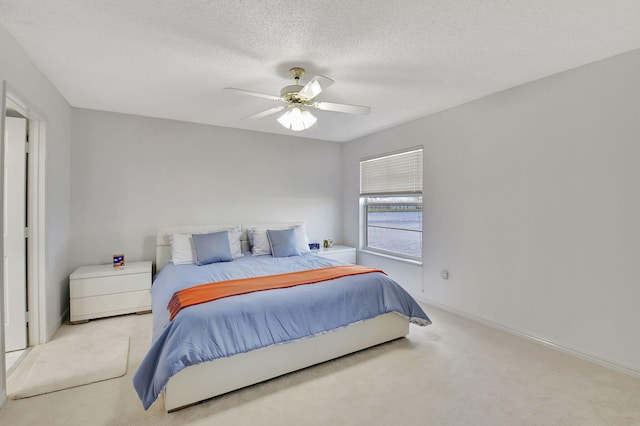 carpeted bedroom featuring a textured ceiling and ceiling fan