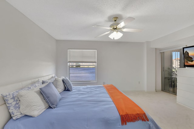 bedroom with carpet flooring, ceiling fan, and a textured ceiling