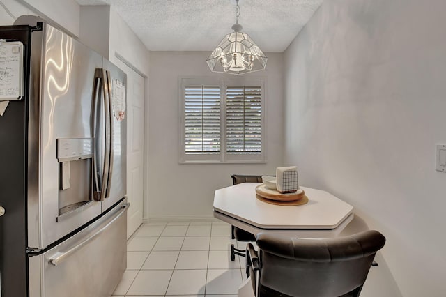 dining room featuring light tile patterned floors, a chandelier, and a textured ceiling