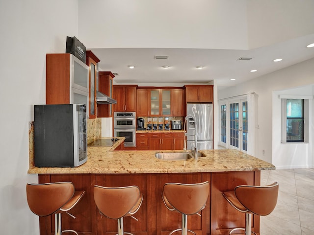 kitchen featuring french doors, decorative backsplash, light tile patterned flooring, kitchen peninsula, and stainless steel appliances