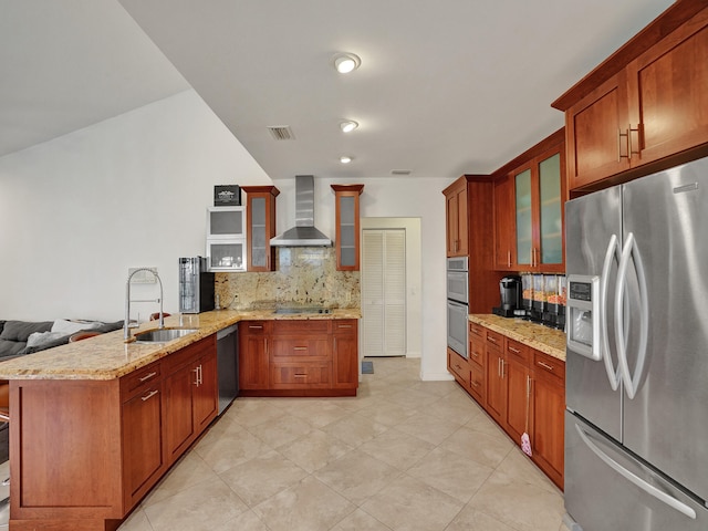 kitchen with kitchen peninsula, backsplash, wall chimney exhaust hood, stainless steel appliances, and sink