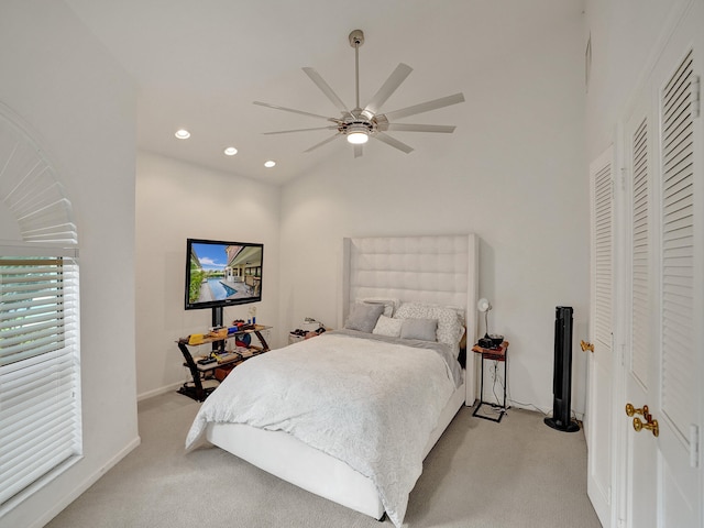 bedroom with ceiling fan, light carpet, and vaulted ceiling