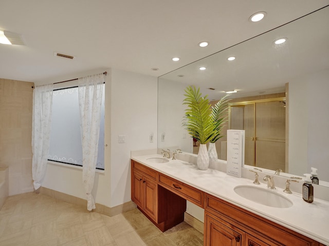 bathroom featuring a shower with door and vanity