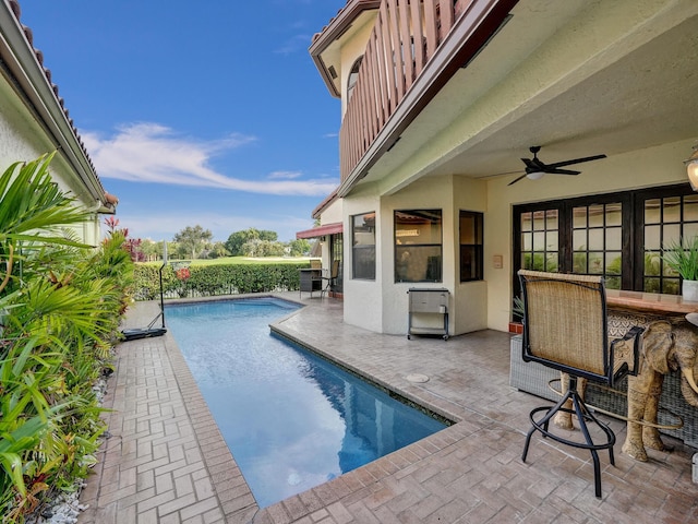 view of swimming pool featuring a patio and ceiling fan