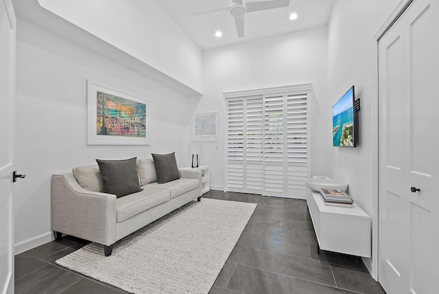 living room with dark tile patterned flooring and ceiling fan