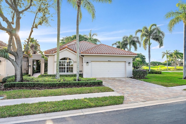 mediterranean / spanish-style house featuring a garage and a front lawn