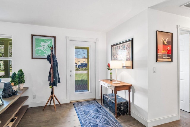 foyer entrance featuring visible vents, baseboards, and wood finished floors