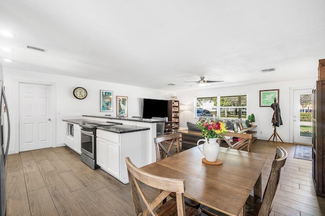 kitchen with ceiling fan, white cabinetry, stainless steel range with electric cooktop, and kitchen peninsula