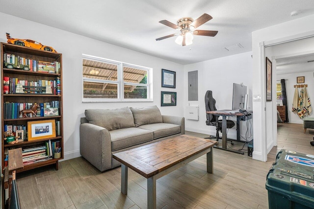 living room with light wood-style floors, electric panel, and ceiling fan