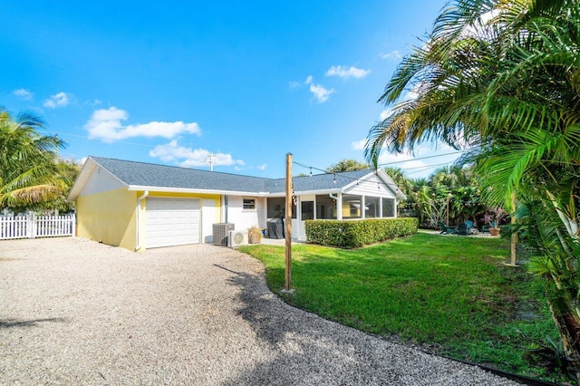 single story home with an attached garage, fence, a front yard, stucco siding, and gravel driveway