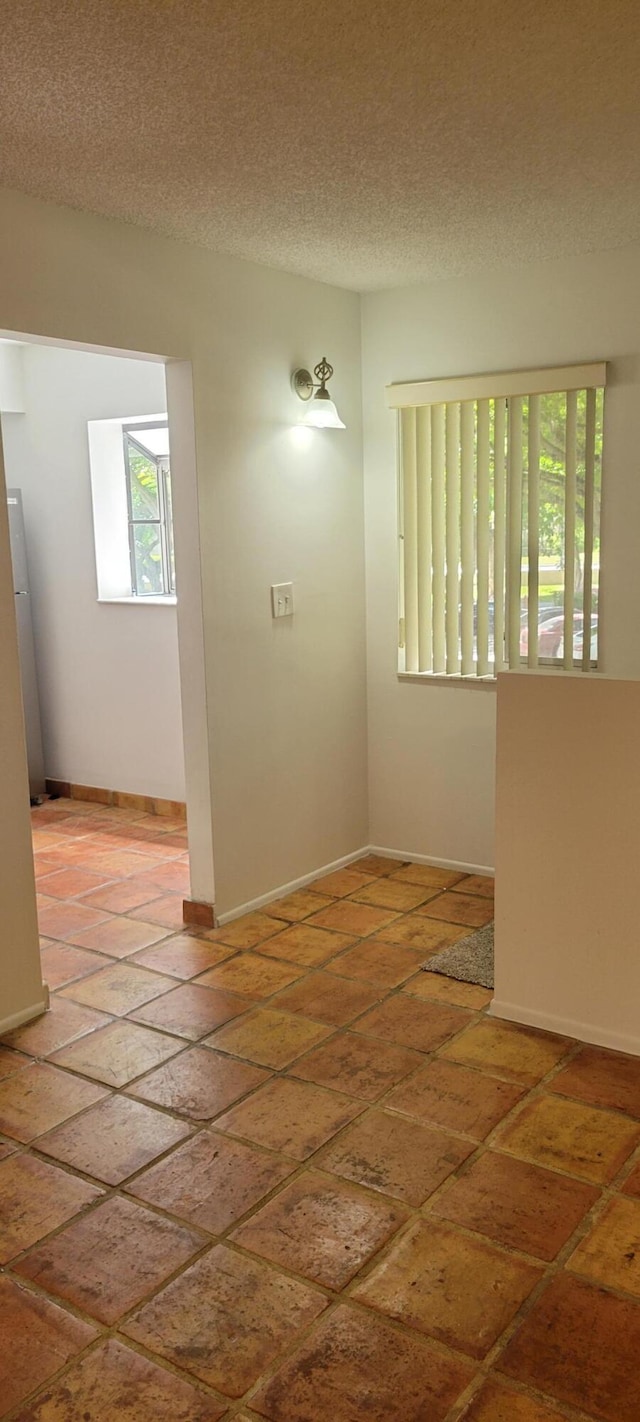 unfurnished room with a textured ceiling