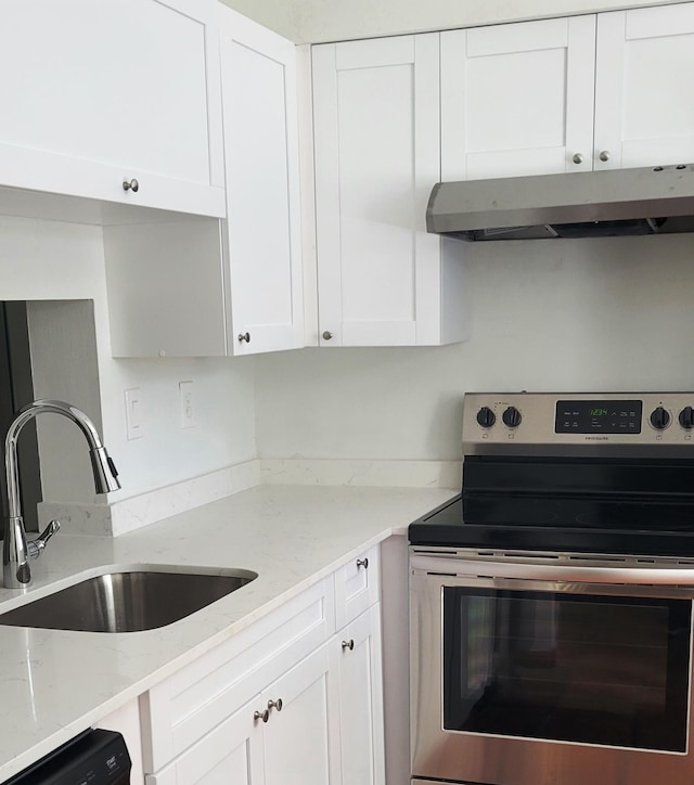 kitchen with white cabinetry, stainless steel electric range oven, sink, and light stone countertops