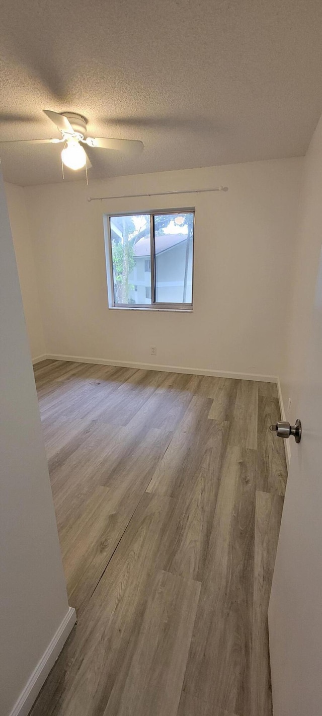 spare room featuring hardwood / wood-style floors, a textured ceiling, and ceiling fan