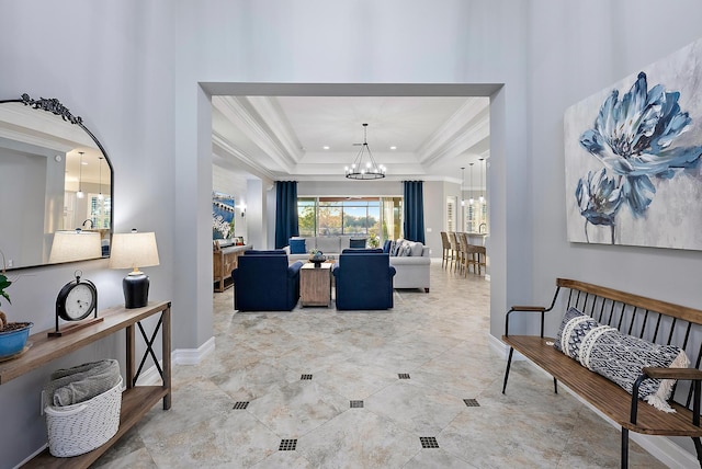 living room with crown molding, an inviting chandelier, and a tray ceiling