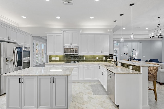 kitchen with kitchen peninsula, sink, white cabinetry, hanging light fixtures, and appliances with stainless steel finishes