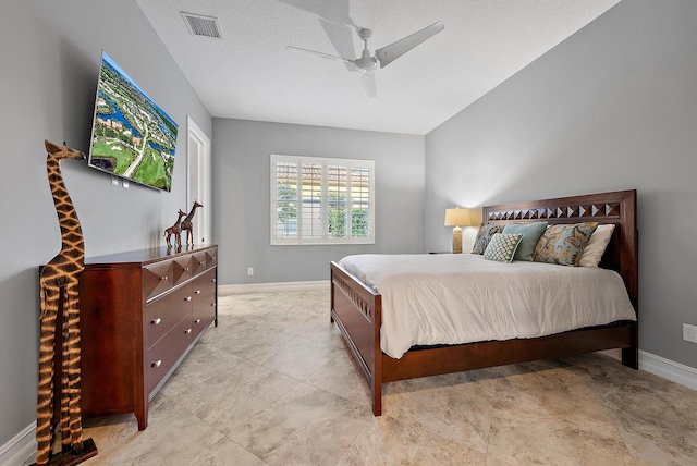 bedroom with ceiling fan and a textured ceiling