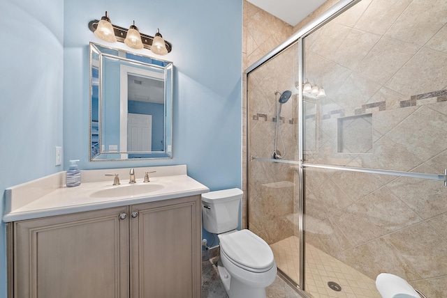 bathroom with toilet, a shower with shower door, and vanity