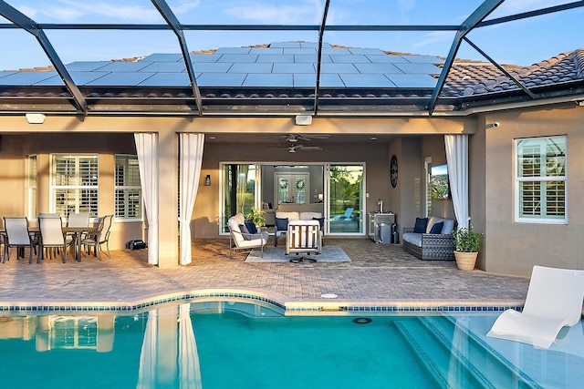 rear view of property with ceiling fan, glass enclosure, outdoor lounge area, and a patio