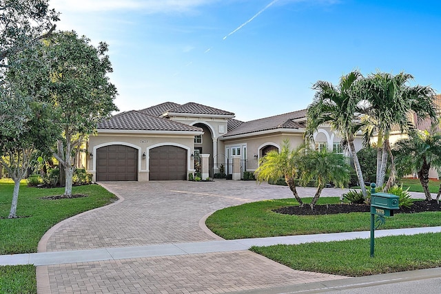 mediterranean / spanish-style house with a garage and a front lawn