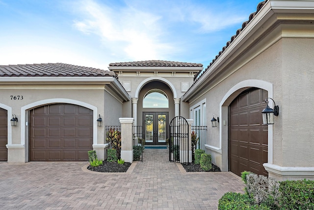 entrance to property with a garage and french doors