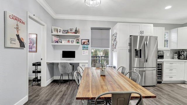 dining space with light hardwood / wood-style floors, wine cooler, and crown molding