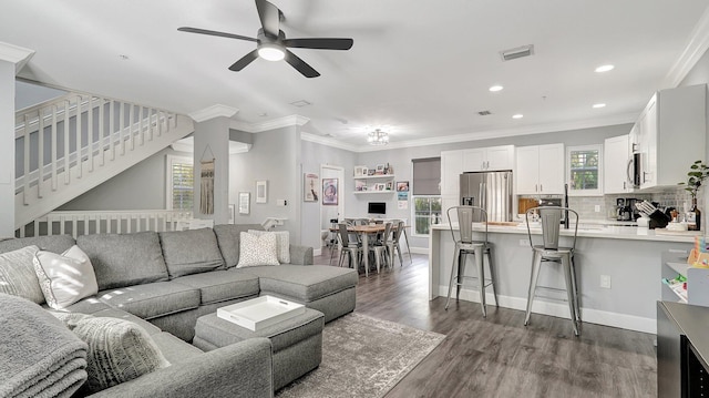 living room featuring ceiling fan, crown molding, and dark wood-type flooring