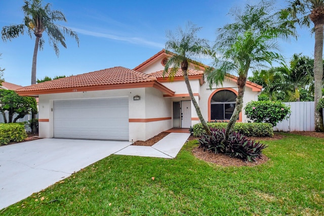 mediterranean / spanish-style home featuring a front lawn and a garage