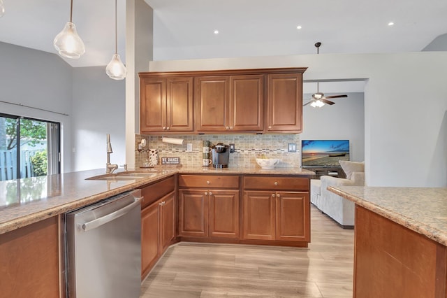 kitchen featuring kitchen peninsula, ceiling fan, hanging light fixtures, stainless steel dishwasher, and sink