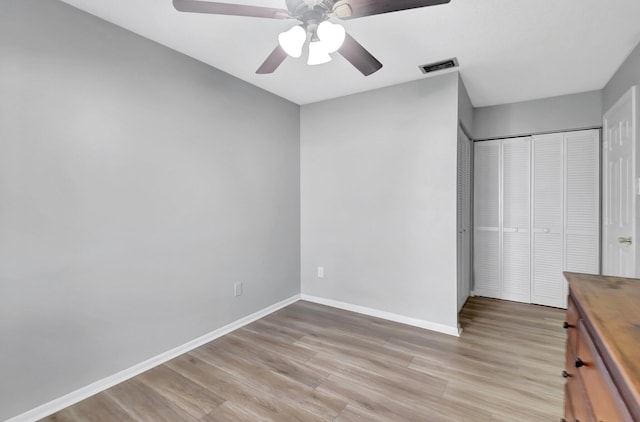 unfurnished bedroom with ceiling fan, light hardwood / wood-style floors, and a closet