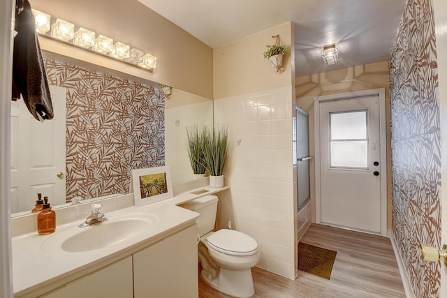 full bathroom featuring toilet, bath / shower combo with glass door, hardwood / wood-style floors, and vanity