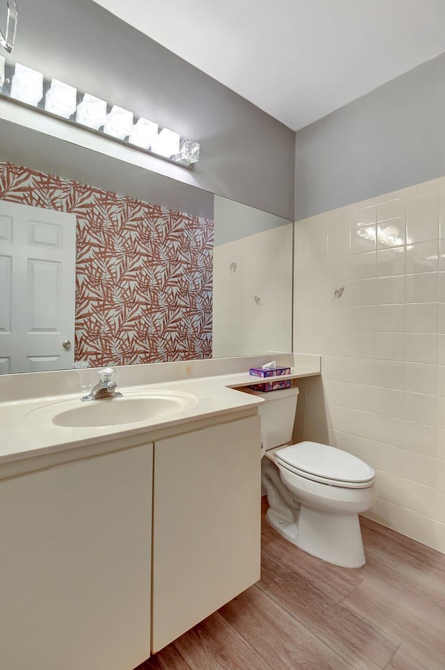 bathroom featuring toilet, vanity, and hardwood / wood-style floors