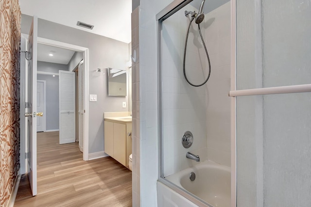 bathroom featuring tiled shower / bath, wood-type flooring, and vanity