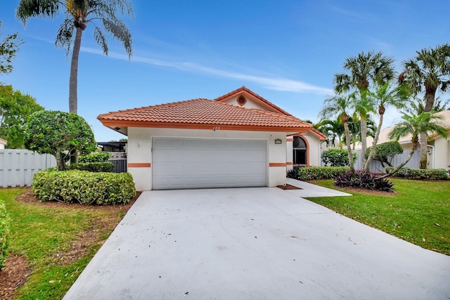 mediterranean / spanish-style home with a garage and a front yard