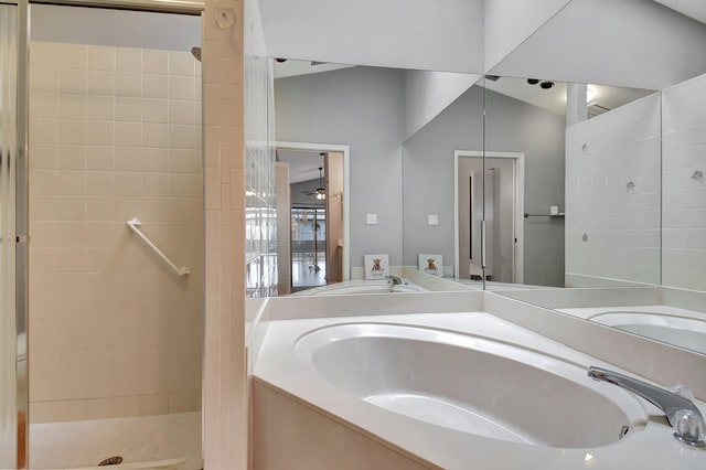 bathroom with vaulted ceiling, tiled shower, and vanity