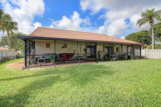 rear view of house with a lawn and a patio