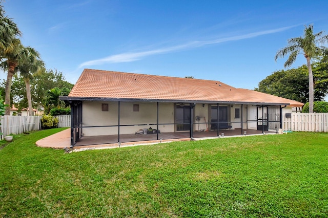 back of property featuring a lawn and a sunroom