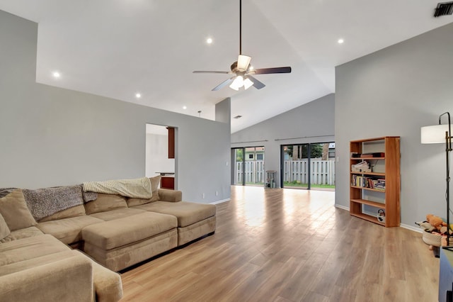 living room featuring ceiling fan, high vaulted ceiling, and light wood-type flooring