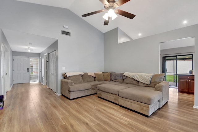 living room with ceiling fan, light hardwood / wood-style flooring, and vaulted ceiling