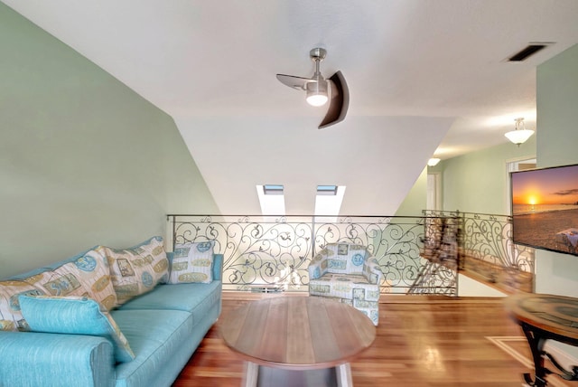 living room featuring hardwood / wood-style flooring, ceiling fan, and lofted ceiling