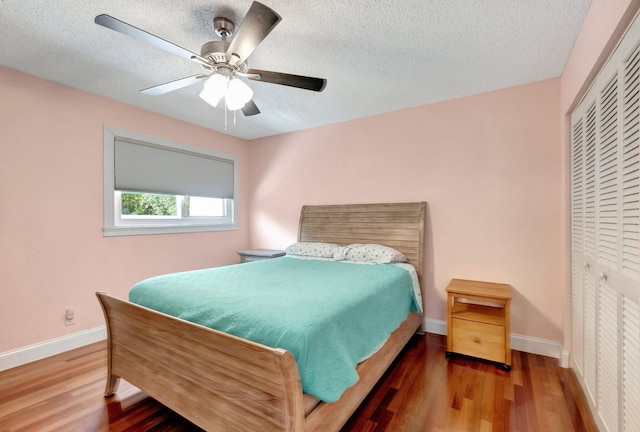 bedroom with ceiling fan, a closet, a textured ceiling, and hardwood / wood-style flooring