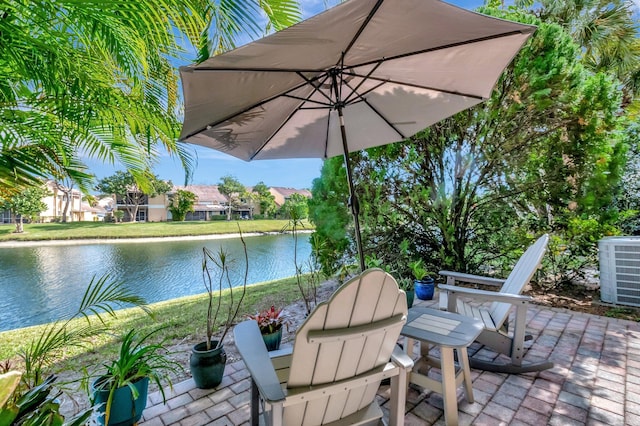 view of patio / terrace featuring a water view and central AC unit