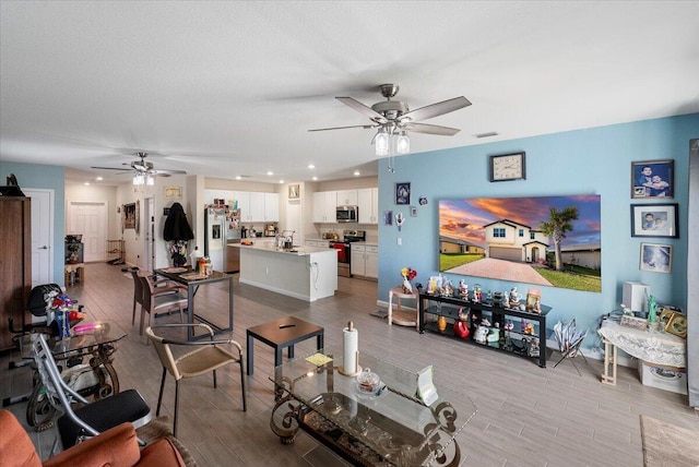 living room featuring a textured ceiling, ceiling fan, and sink