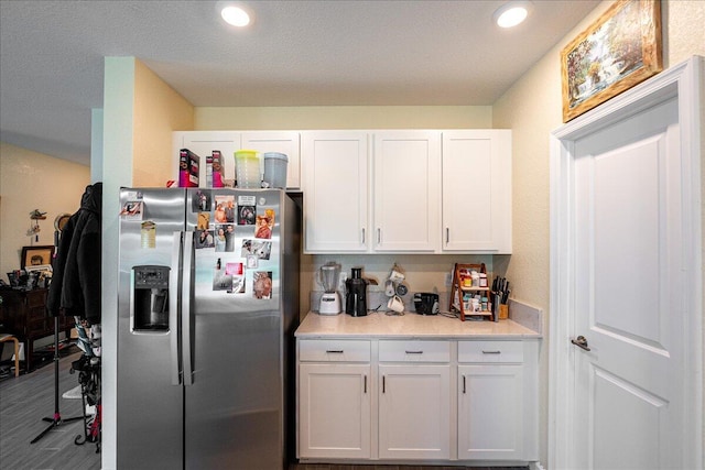 kitchen with stainless steel fridge with ice dispenser, white cabinets, and wood-type flooring